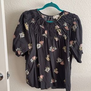Gray flowery blouse.